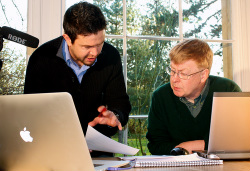2 people discussing a video script infront of a computer